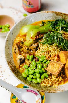 a bowl filled with noodles, vegetables and tofu