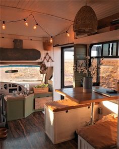 the inside of an rv with wood flooring and lights hanging from it's ceiling