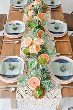 the table is set with succulents and plates