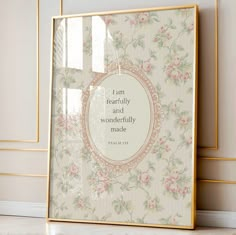 a frame with a quote on it sitting in front of a wallpapered background