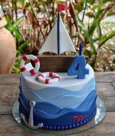 a birthday cake with a sailboat and life preservers on the top is shown