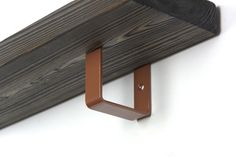 a close up of a wooden shelf with a metal hook on it's side