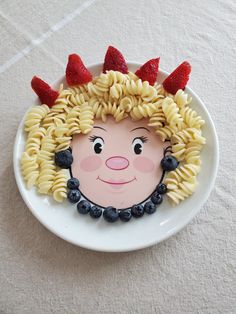 a plate that has some pasta on it with a face made to look like a woman's head