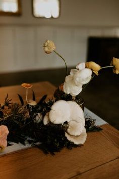 flowers are arranged on a wooden table in a room