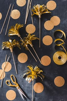 gold foiled palm trees and scissors on a black table with polka dot circles in the background