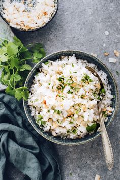 two bowls filled with rice and garnished with cilantro on the side