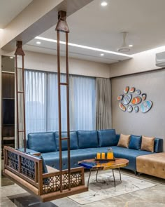 a living room with blue couches and wooden tables in front of a large window