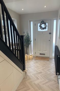 an entry way with a white door and black banisters on the side walk