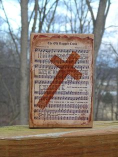 a wooden cross sitting on top of a piece of paper with musical notes in the background