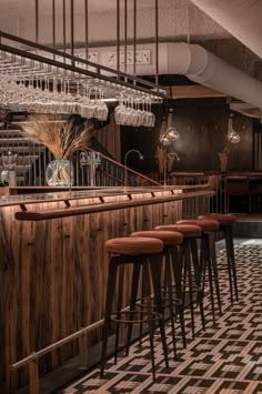 a bar with stools and chandeliers hanging from the ceiling