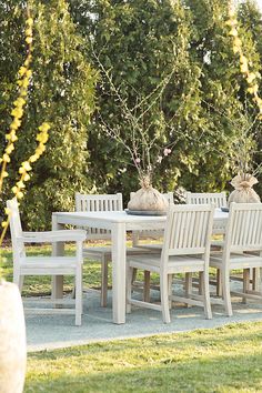 an outdoor table and chairs in the grass