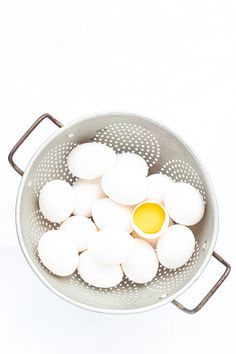 eggs are in a colander with a yellow egg yolk on the top and bottom