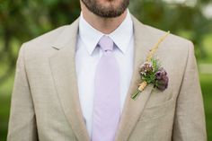 a man in a suit and tie with a boutonniere on his lapel