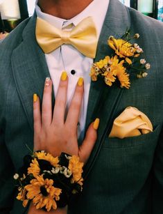 a man in a tuxedo with yellow flowers on his lapel and ring