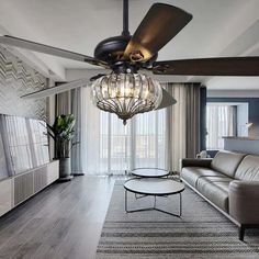 a living room with a couch, coffee table and ceiling fan that is hanging from the ceiling