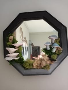 a mirror that has some plants in it and mushrooms on the wall behind it,