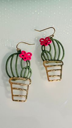 the earrings are decorated with flowers and metal wire, while they stand on a white surface