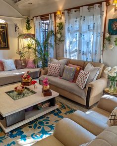 a living room filled with lots of furniture and flowers on the table in front of it