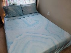 a bed with blue and white sheets in a room