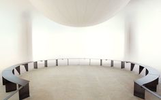 an empty circular room with benches in it