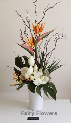 a white vase filled with flowers on top of a table