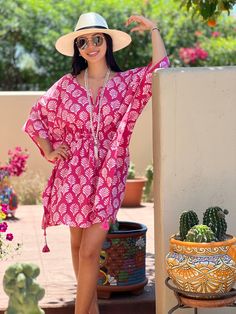 Merriam-Webster defines fanfare as a “showy, outward display.” In fact, our Fanfare Short Kaftan Dress is the perfect shade of pink to ready you for a showy, outward, display of fun and frolic. This beautiful print is made using the age old Dabu printing process. The Fanfare is block printed by hand with mud onto white fabric which is then dyed pink. The mud resists the dye and after being thoroughly washed, the fanfare design is left intact in white with a crackled effect that makes each piece Pink Printed Beachwear Dress, Pink Printed Tunic Dress, Pink Summer Tunic Dress, Pink Tunic Summer Dress, Pink Tunic Dress For The Beach, Pink Printed Short Sleeve Kaftan, Pink Short Sleeve Beachwear Kaftan, Pink Short Sleeve Kaftan For Beachwear, Pink Tunic Dress For Vacation