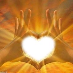 two hands in the shape of a heart against an orange and yellow sky with sun rays