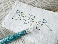 a cross stitch bookmark with the word brother on it next to an open book