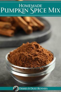 homemade pumpkin spice mix in a glass bowl with cinnamon sticks on the table behind it