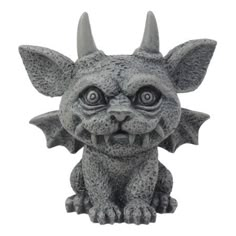 a small statue of a dragon with big eyes and large horns on it's head