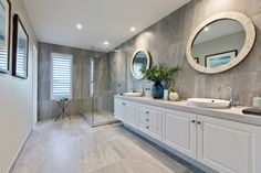 a large bathroom with two sinks and mirrors