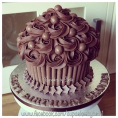 a large chocolate cupcake sitting on top of a cake plate