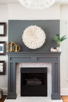 a living room with a fire place and pictures on the wall above it, along with a white rug