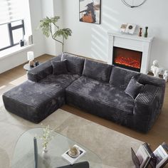 a living room with a large sectional couch in front of a fire place on the wall