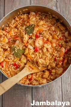 a pot filled with rice and vegetables on top of a wooden table