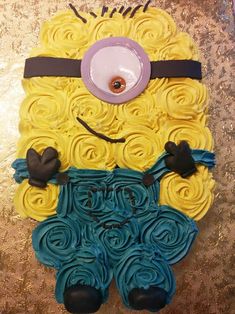 a cake made to look like a minion with yellow and blue icing on it