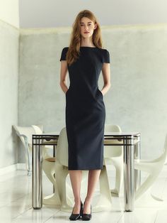 This sophisticated sheath dress features a sleek, form-fitting silhouette that extends to a midi length, providing an elegant and streamlined look. The dress is characterized by short, structured sleeves and a round neckline that add a touch of classic style. Its tailored fit highlights the natural curves of the body while maintaining a professional and polished appearance. The fabric is a dense, smooth textile, enhancing the dress's quality and ensuring it holds its shape throughout wear.- The structured sleeves and round neckline create a balanced and refined look, suitable for business or formal occasions.- Its solid black color adds to the versatility, making it easy to accessorize with a range of colors and styles.- The dress's midi length not only contributes to its elegance but also Structured Knee-length Evening Midi Dress, Structured Knee-length Midi Dress For Evening, Fitted Sleek Sheath Midi Dress, Sleek Bodycon Sheath Midi Dress, Sleek Fitted Sheath Midi Dress, Structured Formal Midi Dress, Fitted Midi-length Bodycon Dress For Business, Classic Bodycon Short Sleeve Midi Dress, Formal Knee-length Bodycon Dress With Flattering Silhouette