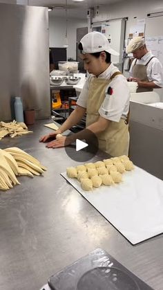 two workers in a kitchen making doughnuts and bananas