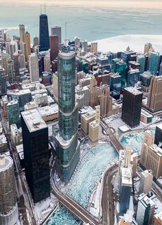 an aerial view of a city with skyscrapers and snow on the ground in winter