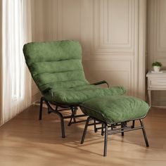 a green chair and ottoman in an empty room