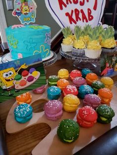 a table topped with lots of cupcakes covered in frosting