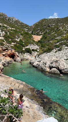 people are swimming in the clear blue water