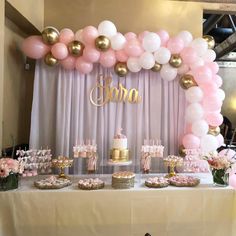 a table topped with lots of pink and white balloons