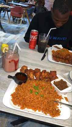 two people sitting at a table with plates of food