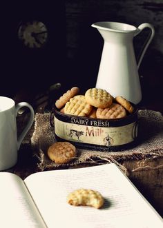 there are cookies and crackers on the table next to an open book