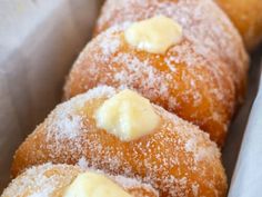 three donuts covered in powdered sugar with butter on them sitting in a box