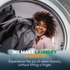 a woman is smiling as she looks out the window of a washing machine with her clothes in it