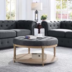 a living room with grey couches and a round coffee table