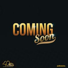 the coming soon logo is shown in gold and black with an orange light shining on it