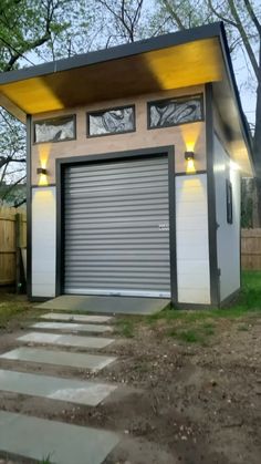 a small garage with a yellow roof and two windows on the top floor, in front of a fenced yard